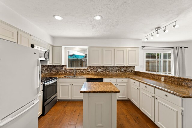 14721 Perthshire Rd, Houston, TX 77079 - kitchen with freestanding refrigerator, stainless steel electric range oven, a sink, a kitchen island, and tasteful backsplash