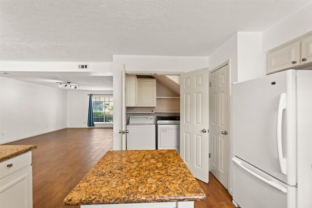 14721 Perthshire Rd, Houston, TX 77079 - kitchen featuring freestanding refrigerator, independent washer and dryer, dark wood-style flooring, a center island, and a textured ceiling