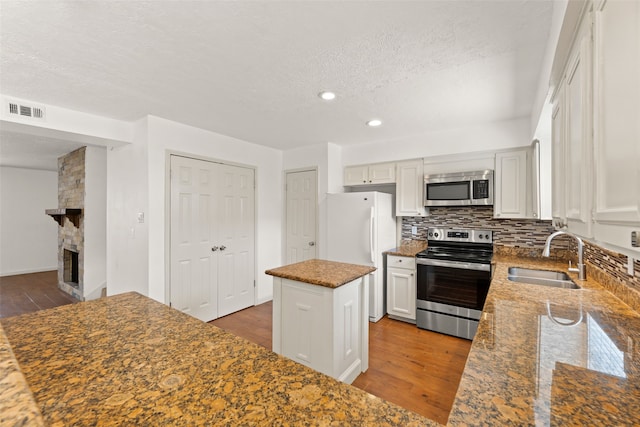 14721 Perthshire Rd, Houston, TX 77079 - kitchen with appliances with stainless steel finishes, a sink, a center island, wood finished floors, and backsplash