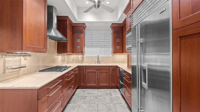4868 Post Oak Timber Dr, Houston, TX 77056 - kitchen with stainless steel appliances, wall chimney range hood, ceiling fan, glass insert cabinets, and light stone countertops