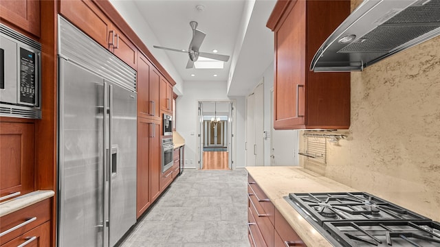 4868 Post Oak Timber Dr, Houston, TX 77056 - kitchen featuring built in appliances, extractor fan, a skylight, brown cabinetry, and recessed lighting