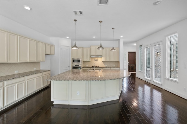 211 Twilight Toast Dr, Conroe, TX 77304 - kitchen featuring appliances with stainless steel finishes, cream cabinetry, decorative backsplash, and recessed lighting