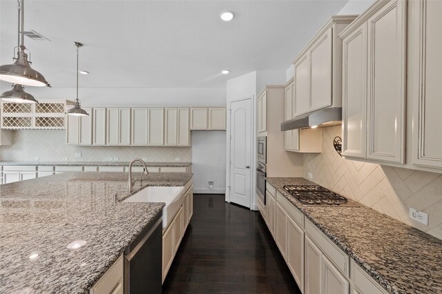 211 Twilight Toast Dr, Conroe, TX 77304 - kitchen featuring a sink, appliances with stainless steel finishes, under cabinet range hood, light stone counters, and tasteful backsplash