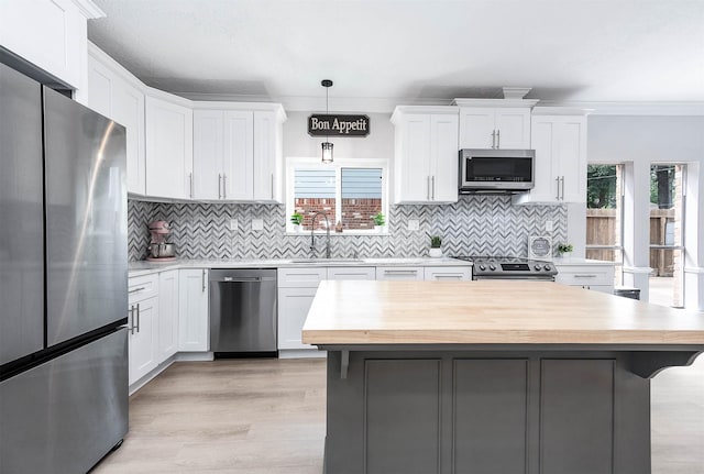 17706 August Meadows Ln, Spring, TX 77379 - kitchen featuring appliances with stainless steel finishes, a sink, white cabinetry, decorative backsplash, and ornamental molding