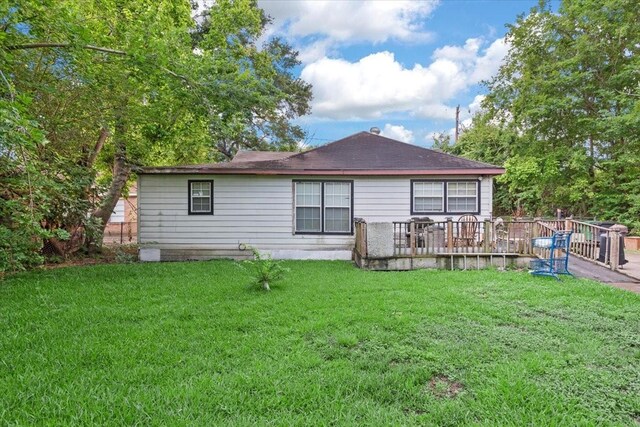 315 E Whitney St, Houston, TX 77022 - back of house featuring a lawn, a wooden deck, and a shingled roof