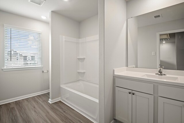 15695 Honey Cove Dr, Conroe, TX 77303 - full bathroom with vanity, wood finished floors, tub / shower combination, and baseboards