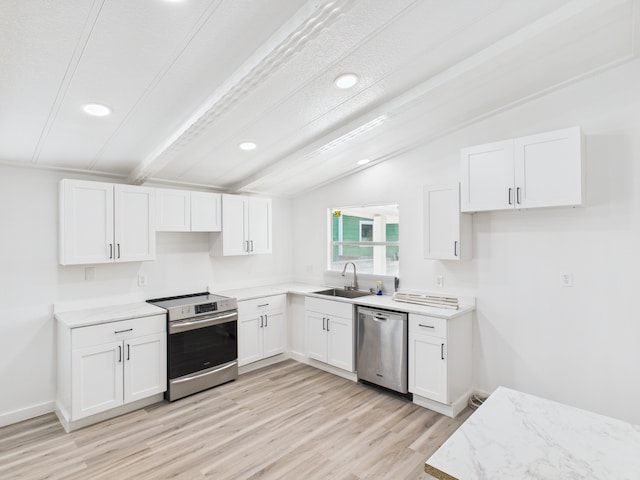 314 S 7th St, Rockport, TX 78382 - kitchen with appliances with stainless steel finishes, a sink, white cabinetry, light wood-style flooring, and recessed lighting