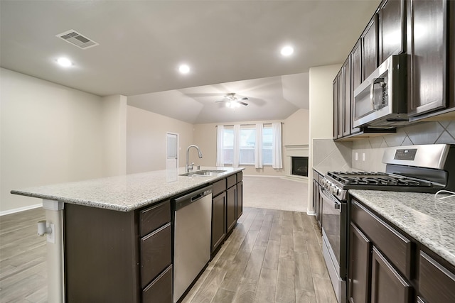 4502 Kayden Berry Ct, Rosenberg, TX 77471 - kitchen with appliances with stainless steel finishes, a sink, light wood finished floors, baseboards, and recessed lighting