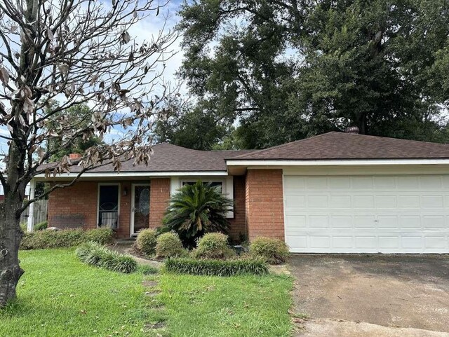 718 Westbury St, West Orange, TX 77630 - ranch-style house with brick siding, concrete driveway, a front lawn, and a garage