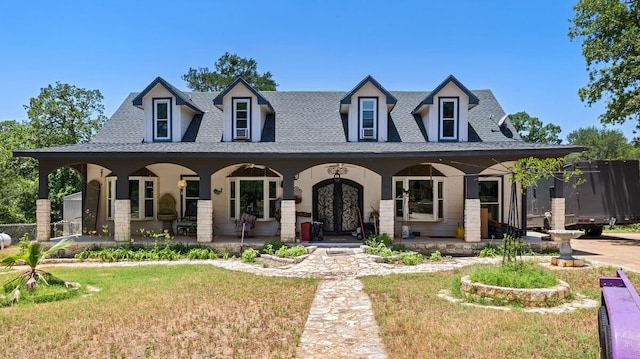 368 Riddle Rd, Cedar Creek, TX 78612 - view of front of home featuring a porch, a shingled roof, a front lawn, and french doors