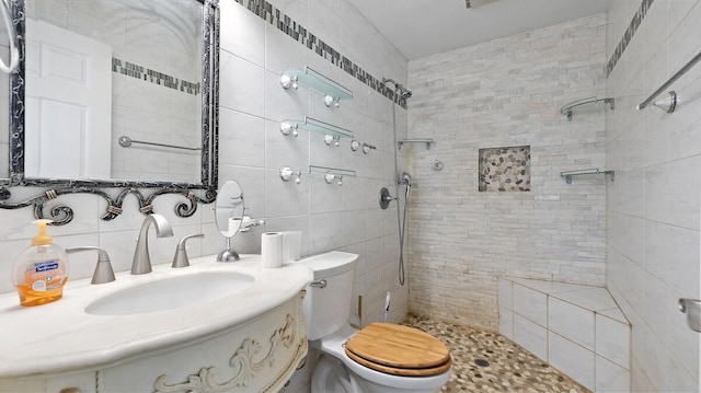 368 Riddle Rd, Cedar Creek, TX 78612 - bathroom featuring a tile shower, toilet, tile walls, decorative backsplash, and vanity