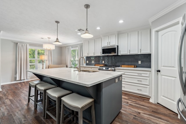 129 Bridgepoint, Onalaska, TX 77360 - kitchen with appliances with stainless steel finishes, a sink, ornamental molding, tasteful backsplash, and white cabinetry