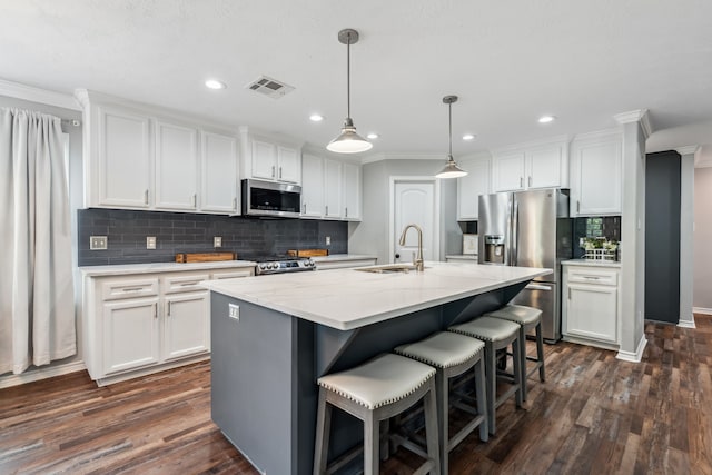 129 Bridgepoint, Onalaska, TX 77360 - kitchen with stainless steel appliances, a sink, white cabinets, ornamental molding, and recessed lighting