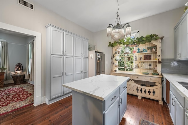 811 18th St, Galveston, TX 77550 - kitchen with dark wood-style flooring, a chandelier, light stone counters, open shelves, and tasteful backsplash