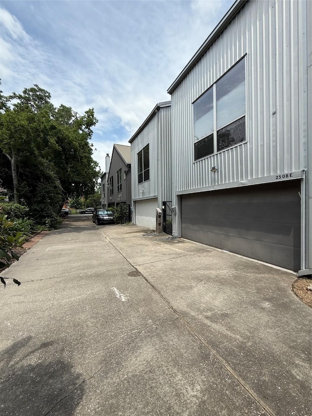 2508 Calumet St Unit E, Houston, TX 77004 - view of home's exterior with a garage, concrete driveway, and board and batten siding