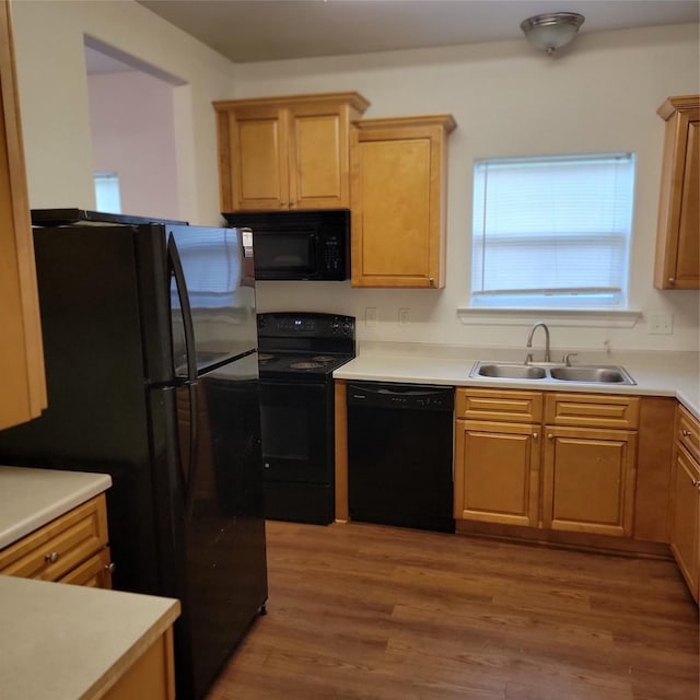 322 7th Ave N, Texas City, TX 77590 - kitchen featuring black appliances, a sink, light wood-style flooring, light countertops, and light brown cabinets