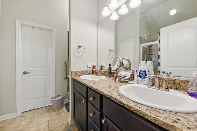 2209 Parker Ct, Brenham, TX 77833 - full bathroom featuring double vanity, a stall shower, baseboards, and stone finish floors