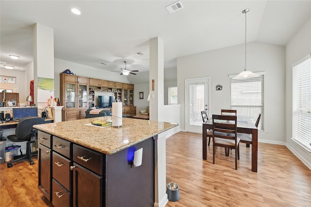 2209 Parker Ct, Brenham, TX 77833 - kitchen featuring lofted ceiling, light wood-style flooring, open floor plan, ceiling fan, and light stone counters