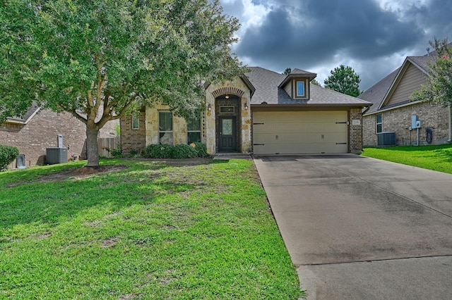 2209 Parker Ct, Brenham, TX 77833 - view of front of home featuring central air condition unit, brick siding, concrete driveway, and a garage