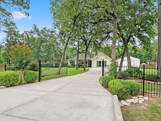 136 Fantail St, Magnolia, TX 77355 - view of front facade featuring driveway, view of scattered trees, and a gate