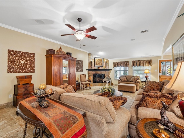 136 Fantail St, Magnolia, TX 77355 - living room featuring crown molding, a ceiling fan, a stone fireplace, and light stone finish flooring
