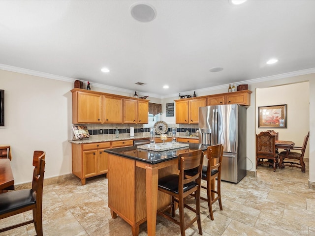 136 Fantail St, Magnolia, TX 77355 - kitchen with stainless steel fridge with ice dispenser, ornamental molding, a kitchen island, backsplash, and a kitchen breakfast bar