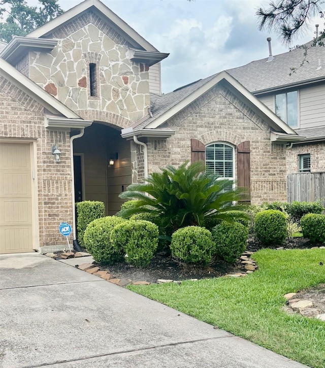 17023 Tallgrass Prairie Ln, Humble, TX 77346 - view of front of home with brick siding, concrete driveway, an attached garage, and stone siding
