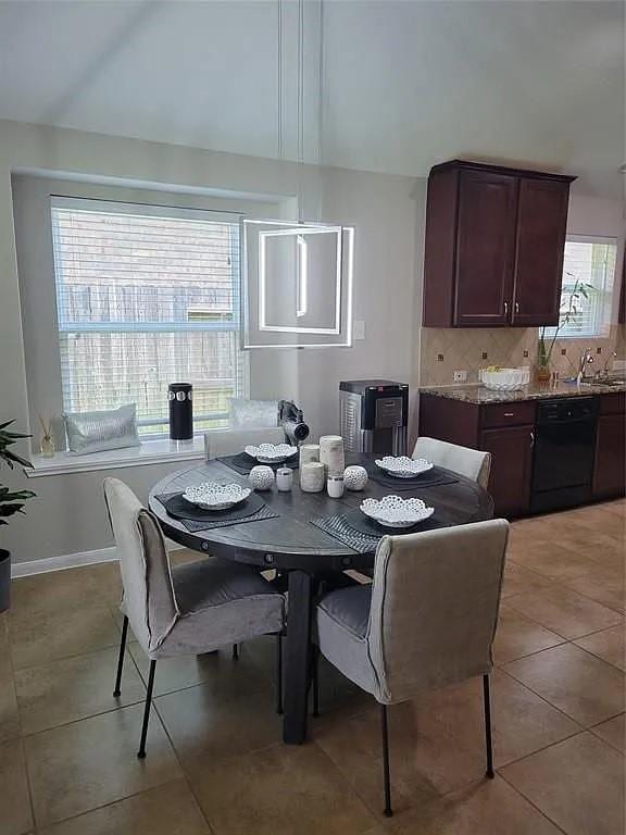 17023 Tallgrass Prairie Ln, Humble, TX 77346 - dining space featuring light tile patterned floors, a towering ceiling, and baseboards