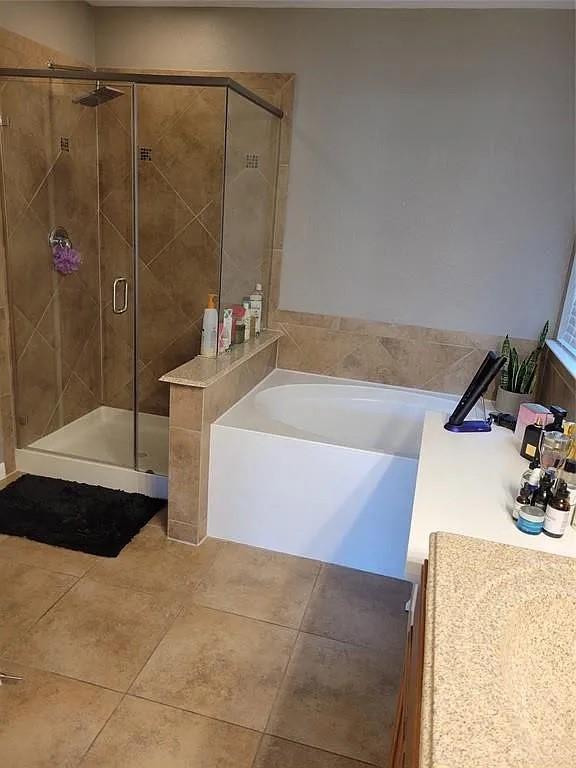 17023 Tallgrass Prairie Ln, Humble, TX 77346 - full bathroom with a bath, a shower stall, tile patterned flooring, and vanity