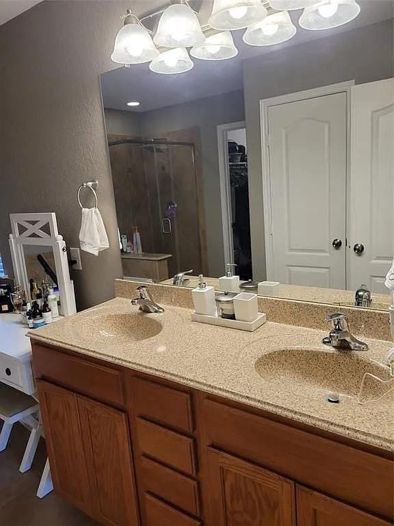 17023 Tallgrass Prairie Ln, Humble, TX 77346 - full bathroom with a shower stall, double vanity, a spacious closet, and a chandelier