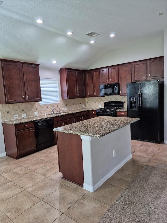 17023 Tallgrass Prairie Ln, Humble, TX 77346 - kitchen with black appliances, light stone counters, tasteful backsplash, a sink, and dark brown cabinets