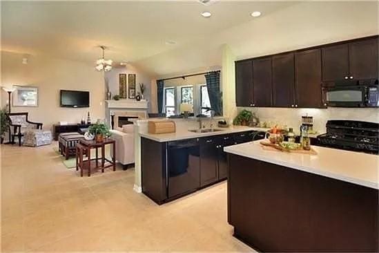 17023 Tallgrass Prairie Ln, Humble, TX 77346 - kitchen with black microwave, range, light countertops, a peninsula, and recessed lighting
