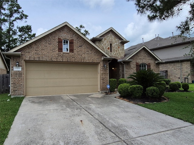 17023 Tallgrass Prairie Ln, Humble, TX 77346 - view of front of home featuring brick siding, a garage, driveway, and a front lawn