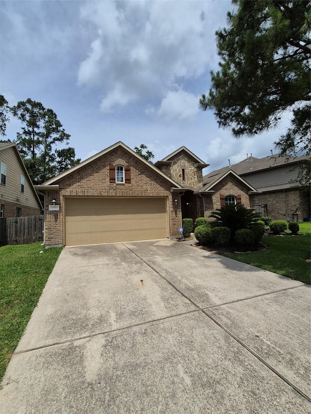 17023 Tallgrass Prairie Ln, Humble, TX 77346 - traditional-style home featuring an attached garage, concrete driveway, brick siding, and stone siding