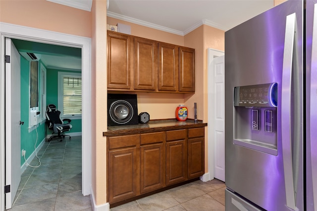 2616 45th St, Galveston, TX 77550 - kitchen featuring stainless steel refrigerator with ice dispenser, dark countertops, ornamental molding, light tile patterned floors, and brown cabinets