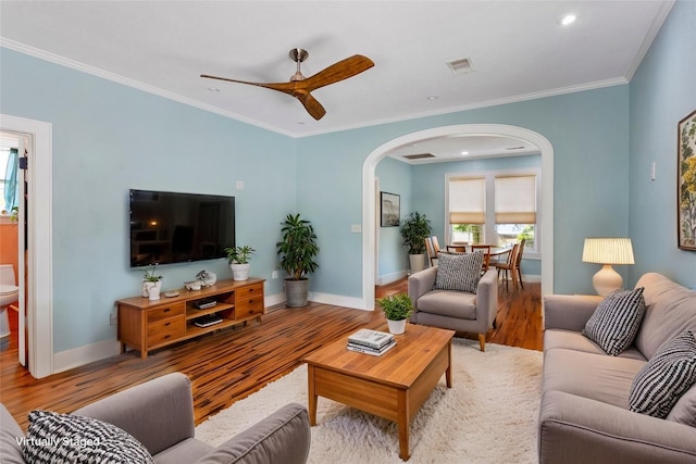 2616 45th St, Galveston, TX 77550 - living room with arched walkways, wood finished floors, baseboards, a ceiling fan, and ornamental molding