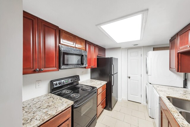 12633 Memorial Dr Unit 179, Houston, TX 77024 - kitchen featuring black appliances, stacked washer and clothes dryer, dark brown cabinets, light stone countertops, and light tile patterned floors