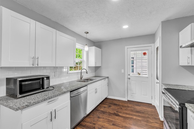 2032 Vince St, Pasadena, TX 77502 - kitchen featuring appliances with stainless steel finishes, a sink, dark wood-style flooring, light stone counters, and tasteful backsplash