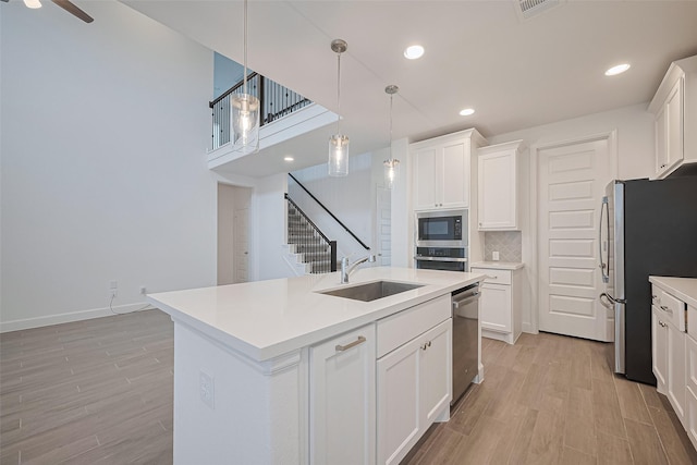 30351 Spragletop View St, Brookshire, TX 77423 - kitchen with stainless steel appliances, a sink, light wood-style floors, white cabinetry, and recessed lighting