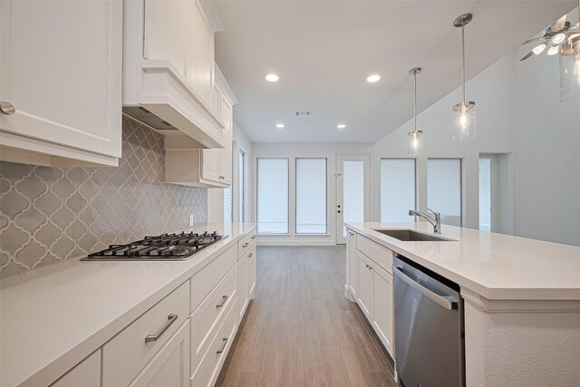 30351 Spragletop View St, Brookshire, TX 77423 - kitchen featuring stainless steel appliances, light countertops, a sink, decorative backsplash, and light wood-style floors