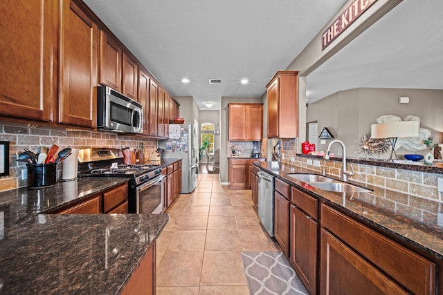 13526 Astley Acres Ln, Cypress, TX 77429 - kitchen with stainless steel appliances, a sink, backsplash, dark stone counters, and light tile patterned flooring