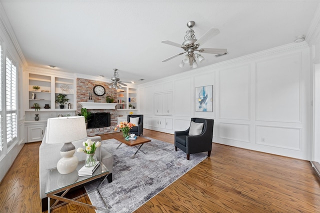 20234 Brondesbury Dr, Katy, TX 77450 - living room with a ceiling fan, a decorative wall, built in features, a brick fireplace, and wood finished floors