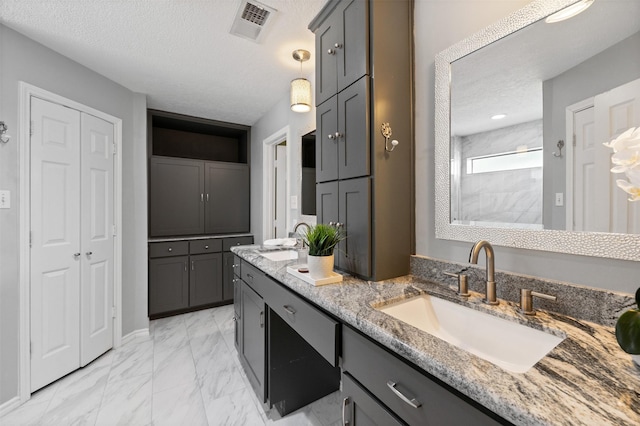 20234 Brondesbury Dr, Katy, TX 77450 - full bathroom with a closet, double vanity, a textured ceiling, marble finish floors, and a tile shower