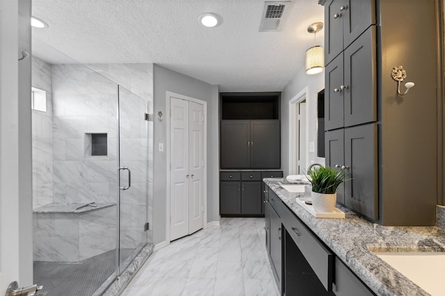 20234 Brondesbury Dr, Katy, TX 77450 - bathroom featuring double vanity, a stall shower, marble finish floors, a textured ceiling, and a closet