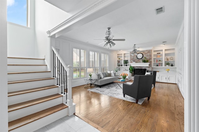 20234 Brondesbury Dr, Katy, TX 77450 - living area featuring ceiling fan, stairway, a large fireplace, built in shelves, and crown molding