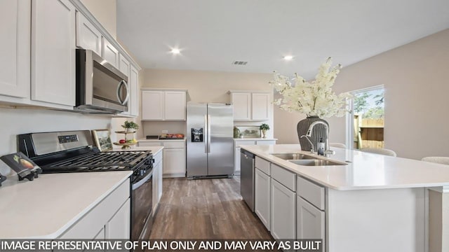 506 Belle Springs Ln, Conroe, TX 77301 - kitchen featuring appliances with stainless steel finishes, a sink, light countertops, wood finished floors, and a kitchen island with sink