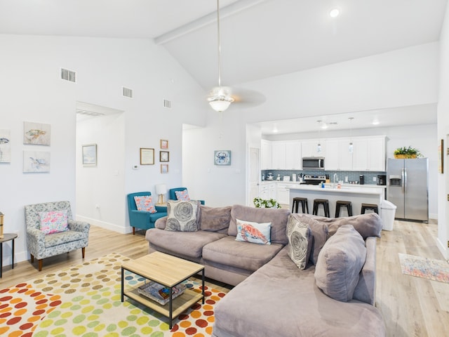 2403 S Bronte St, Rockport, TX 78382 - living room with light wood-style floors, high vaulted ceiling, ceiling fan, beam ceiling, and baseboards