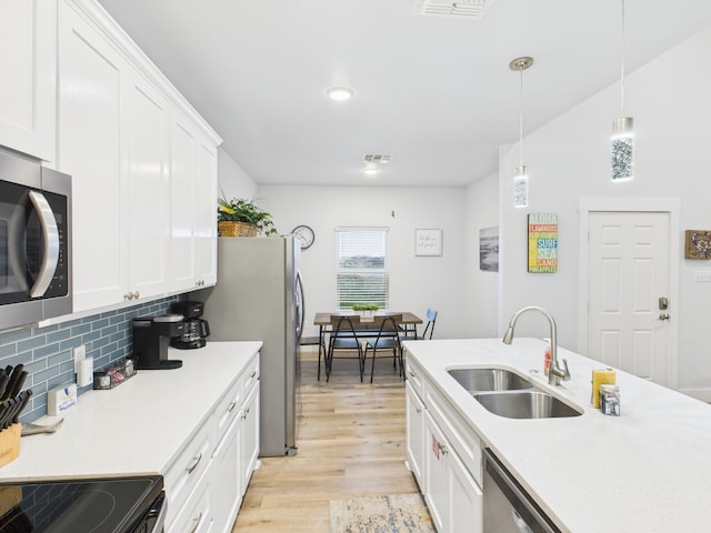 2403 S Bronte St, Rockport, TX 78382 - kitchen with a sink, light wood-type flooring, backsplash, white cabinetry, and light countertops