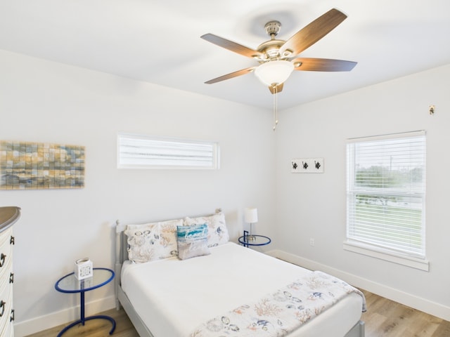 2403 S Bronte St, Rockport, TX 78382 - bedroom featuring multiple windows, baseboards, light wood-style floors, and a ceiling fan