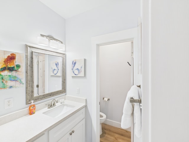 2403 S Bronte St, Rockport, TX 78382 - bathroom featuring toilet, vanity, wood finished floors, and baseboards